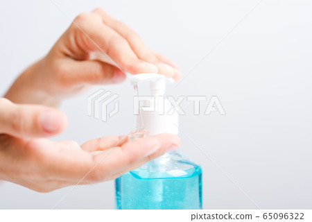 Close up woman applying press dispenser sanitizer 65096322