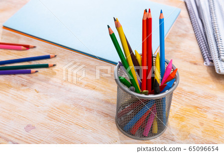 Various color pencils and notebooks on a wooden table Various color pencils and notebooks on a wooden table 65096654