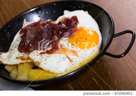 Broken eggs with Jabugo ham 65096901
