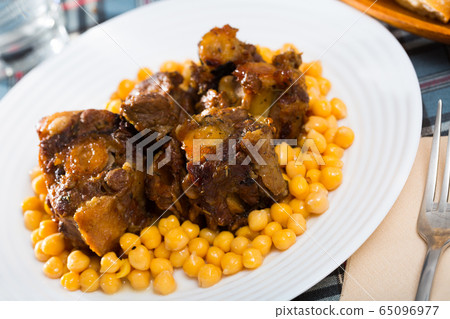 Braised oxtails with chickpeas on a white plate Braised oxtails with chickpeas on a white plate 65096977