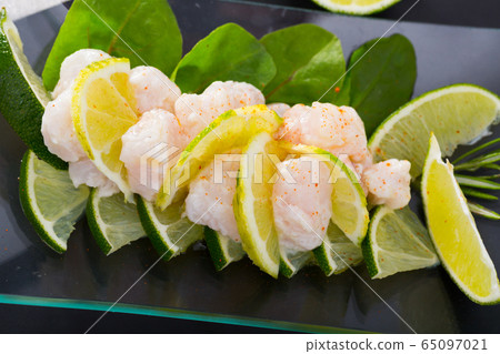 Delicious ceviche from cod on a glass plate with lime and greens 65097021