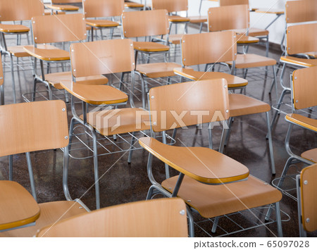 Wooden chairs in rows in classroom of school interior, no people 65097028