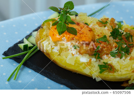 Baked potato with herbs, egg and cucumbers Baked potato with herbs, egg and cucumbers 65097506