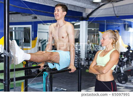 Man doing push-ups with trainer Man doing push-ups with trainer 65097991