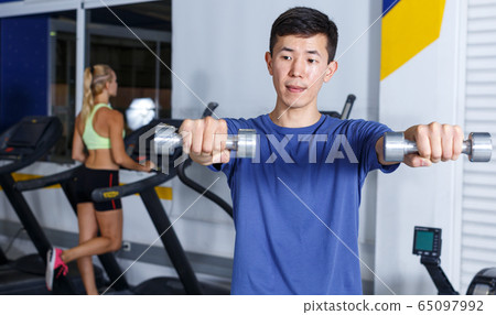 Man doing exercises with dumbbells Man doing exercises with dumbbells 65097992