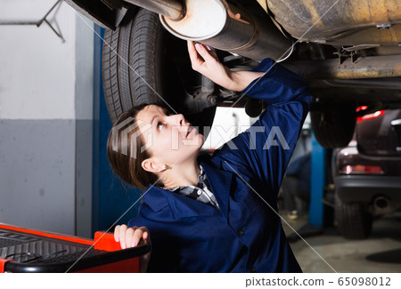 Female is standing near car and repairing Female is standing near car and repairing 65098012