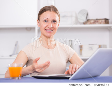 Cheerful woman using laptop Cheerful woman using laptop 65098154
