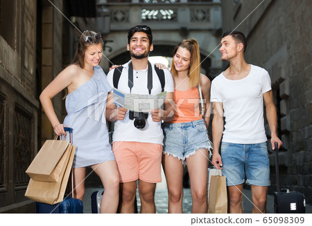 Portrait of happy tourists with map and baggage in European city Portrait of happy tourists with map and baggage in European city 65098309