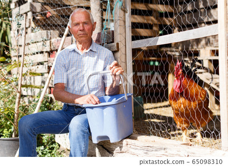 Elderly gardener near henhouse Elderly gardener near henhouse 65098310