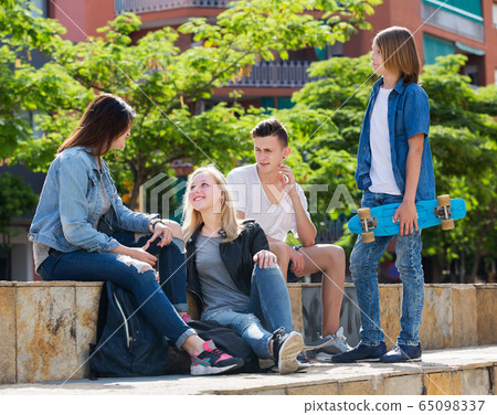 Teenagers friends talking outdoors 65098337