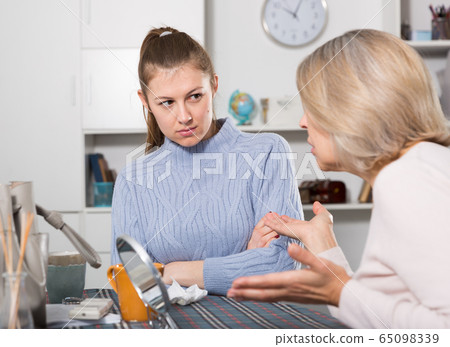 Mature mother and adult daughter quarrelling in domestic interior Mature mother and adult daughter quarrelling in domestic interior 65098339