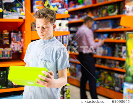 Teenager shopping in toy store Teenager shopping in toy store 65098645