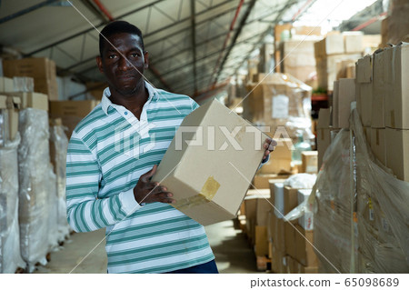 Warehouse owner arranging boxes Warehouse owner arranging boxes 65098689