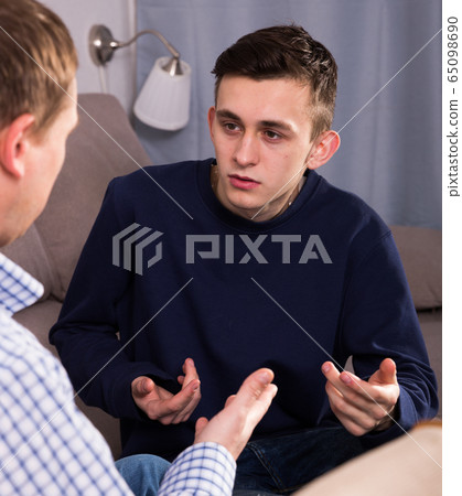 Man with his adult son are serious talking about life together 65098690