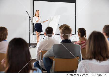 Female student answering in front of student group Female student answering in front of student group 65098734