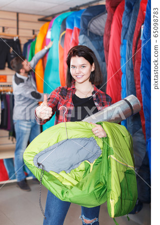Couple examining touristic equipment items Couple examining touristic equipment items 65098783