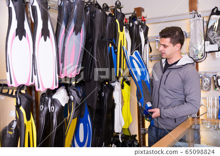 male is choosing new flippers for diving 65098824