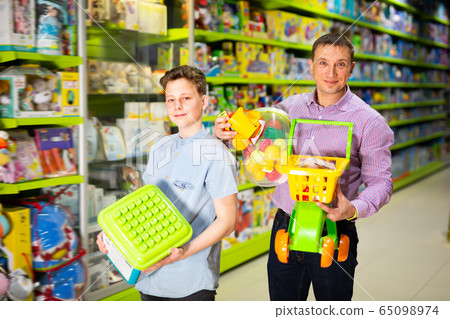 Nice teenager and father standing with purchases Nice teenager and father standing with purchases 65098974