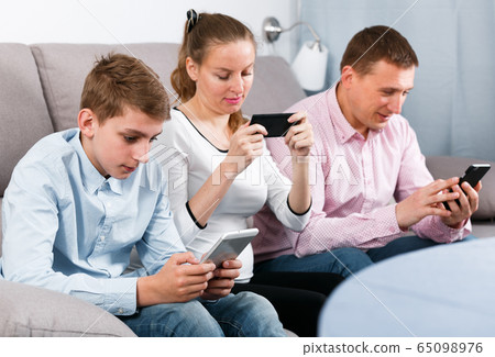 Parents and son using phones 65098976