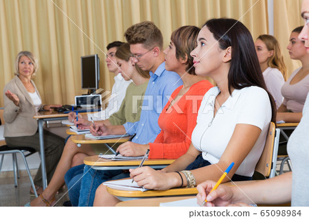 Side view of student group with female teacher on lecture 65098984