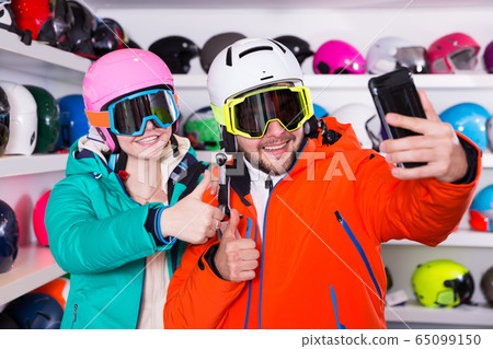Happy couple in skiing outfit making selfie 65099150