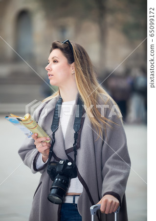 Blond positive girl holding brochure in hands Blond positive girl holding brochure in hands 65099172