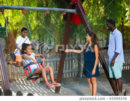 Family having fun on swing 65099248