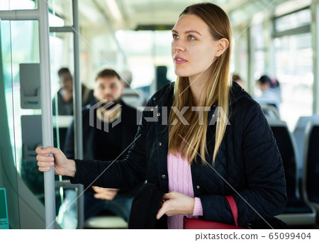 Young woman traveling by city bus 65099404