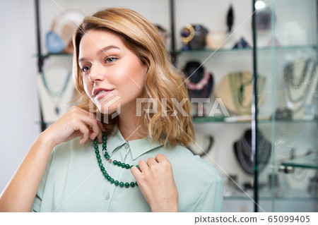 Woman choosing greenstone beads 65099405