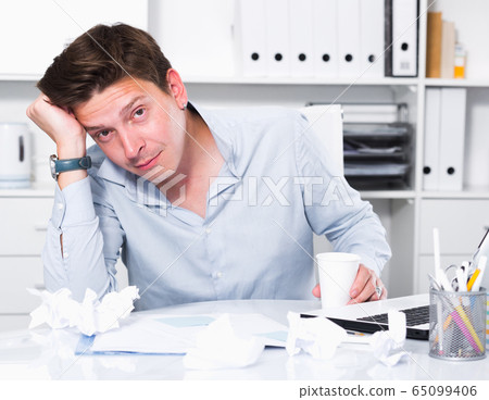 Young sad man tired of working Young sad man tired of working 65099406