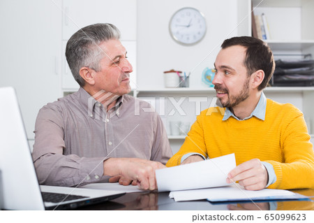 Adult man and agent discuss contract 65099623
