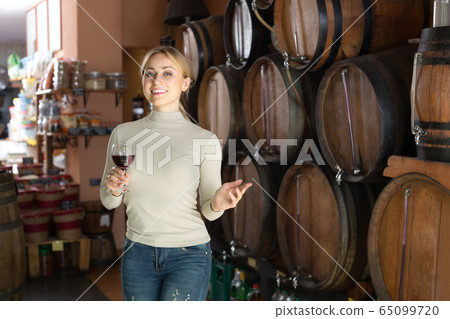 Woman selecting wine in wine house. 65099720