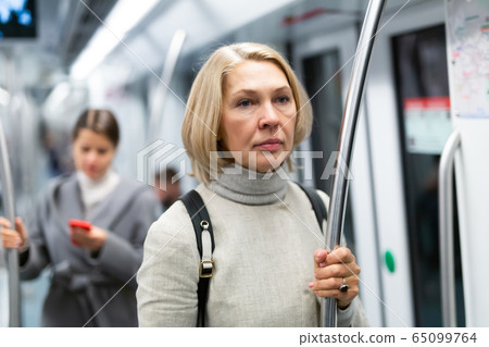 Mature woman in subway car Mature woman in subway car 65099764
