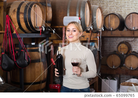 Woman selecting wine in wine house. Woman selecting wine in wine house. 65099765