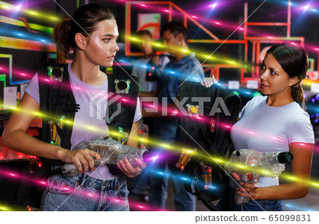 Two girls talking about holding guns and waistcoat Two girls talking about holding guns and waistcoat 65099831