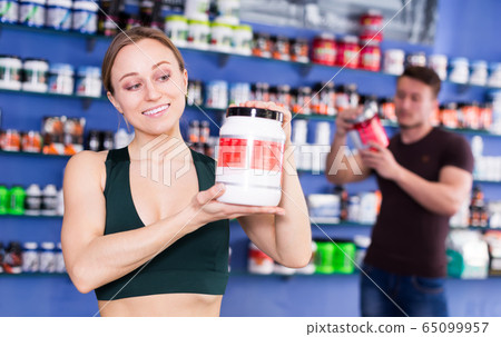woman holding plastic jar of sport food 65099957
