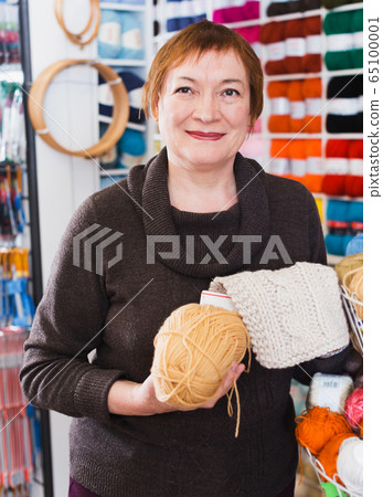 Woman picking yarn in shop Woman picking yarn in shop 65100001