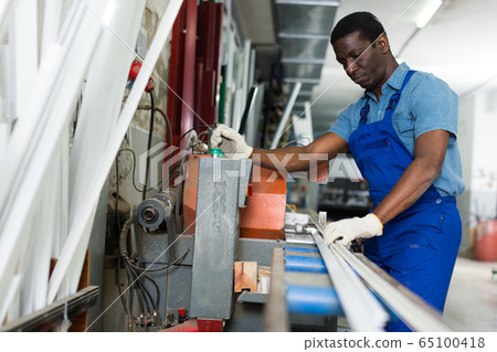 Portrait of man worker who is occupation near special machine 65100418