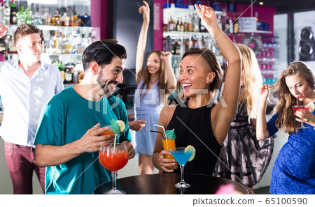 vigorous male with female are talking and drinking cocktails on the party vigorous male with female are talking and drinking cocktails on the party 65100590