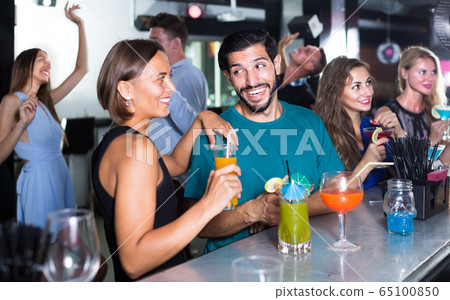 adult vigorous male with female are talking and drinking cocktails on the party adult vigorous male with female are talking and drinking cocktails on the party 65100850