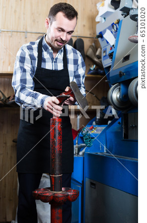 male worker fixing failed shoes in shoe repair workshop male worker fixing failed shoes in shoe repair workshop 65101020