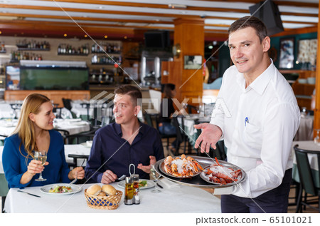 Waiter showing tray of lobsters 65101021