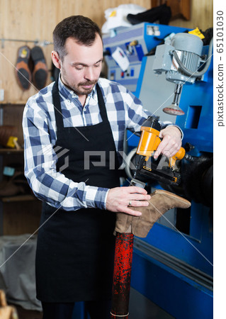 Male worker repairing shoe Male worker repairing shoe 65101030
