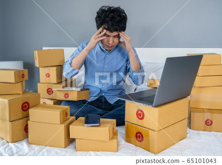 stressed man using laptop computer and working 65101043