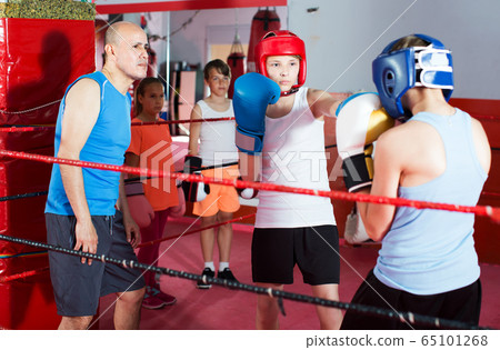 Children training on boxing ring 65101268