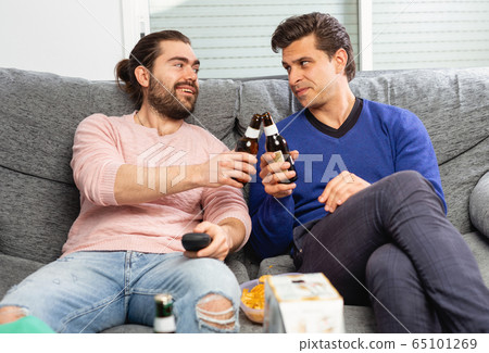 Men rejoice in the victory of their favorite team on TV 65101269