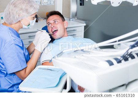 Male patient getting dentist treatment Male patient getting dentist treatment 65101310