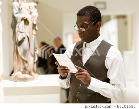 Man reading brochure about exhibits Man reading brochure about exhibits 65101585