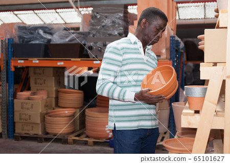 Man choosing pots for flowers in gardening market Man choosing pots for flowers in gardening market 65101627