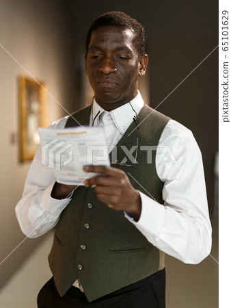 Man looking at painting Man looking at painting 65101629